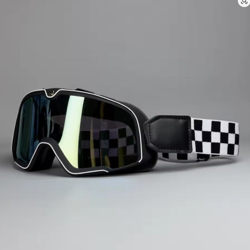 Black Motorcycle goggles with a black and white checkered strap, shown on a neutral gray background.