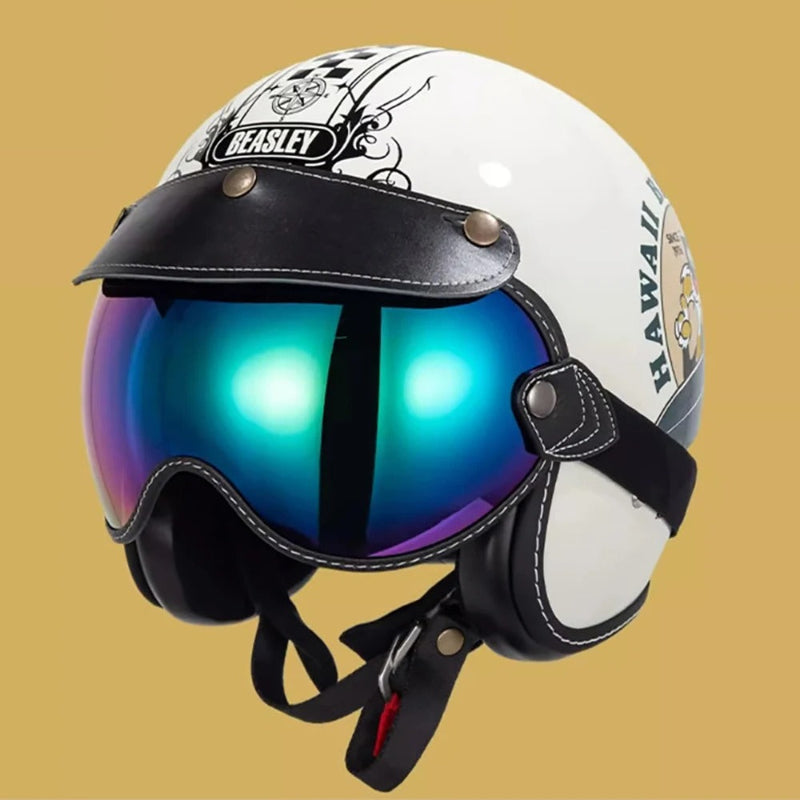 A white retro-style motorcycle helmet with black leather visor and straps, featuring a large mirrored blue-purple visor and decorative black graphics on the side, set against a solid tan background.