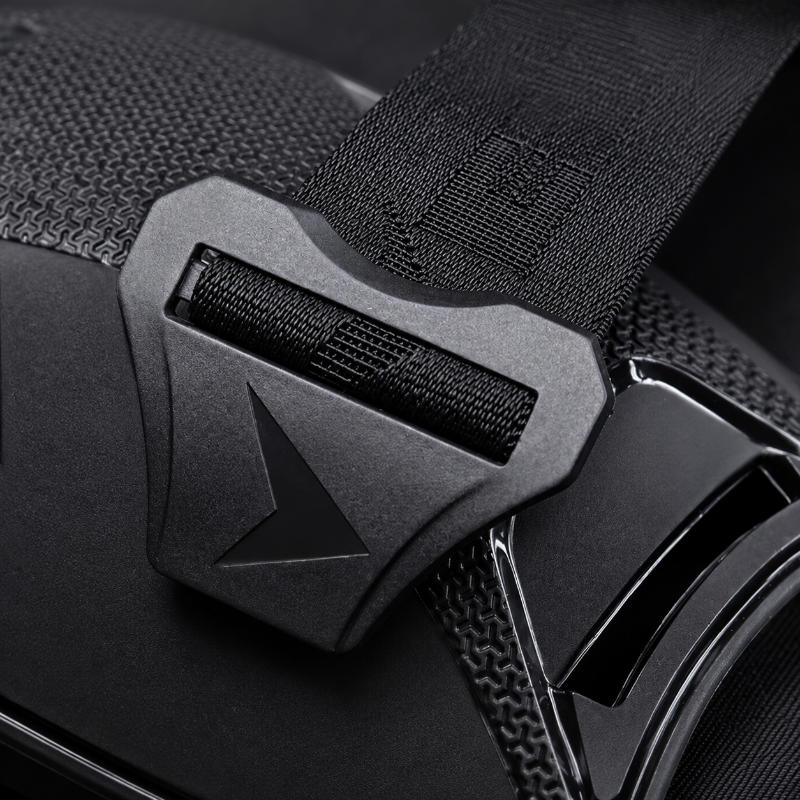 Close-up of a black adjustable strap with a matte black plastic buckle and a textured fabric loop.