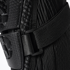 Close-up of a black protective gear item with a textured ribbed fabric body, a wide black strap, and a black plastic buckle.