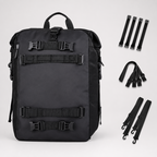 A black backpack shown on a light gray studio background with multiple black strap accessories arranged to the right. The backpack has multiple adjustable buckle straps across the front and side pockets.