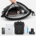 A black crossbody bag with a gray interior is shown open, with a hand lifting the flap to reveal stored items including a laptop, phone, wallet, and water bottle. Below the bag, matching devices and accessories are displayed on a light gray background.