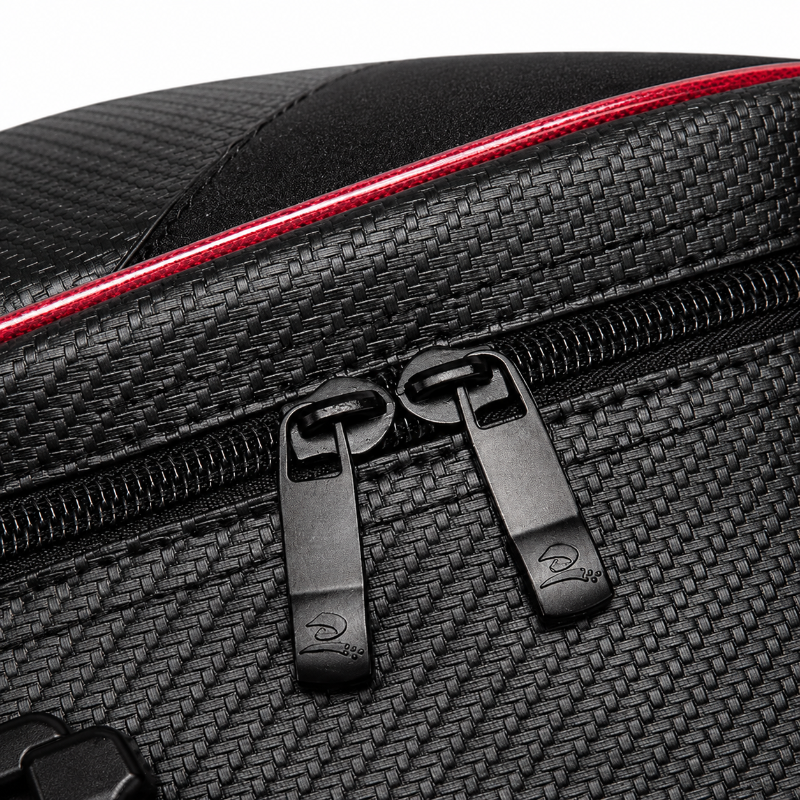 Close-up of a black textured bag with a red accent line and black zipper pulls on a white background.
