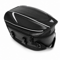 A black motorcycle rear rack bag with a textured carbon-fiber-style pattern, white piping accents, and a small triangular logo on the top right, shown on a white background.