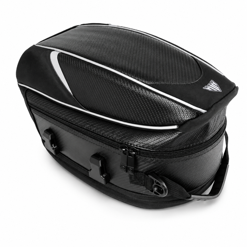 A black motorcycle rear rack bag with a textured carbon-fiber-style pattern, white piping accents, and a small triangular logo on the top right, shown on a white background.