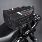 A black motorcycle rear luggage bag with red and white accents, mounted on the back of a black motorcycle against a gray studio background.