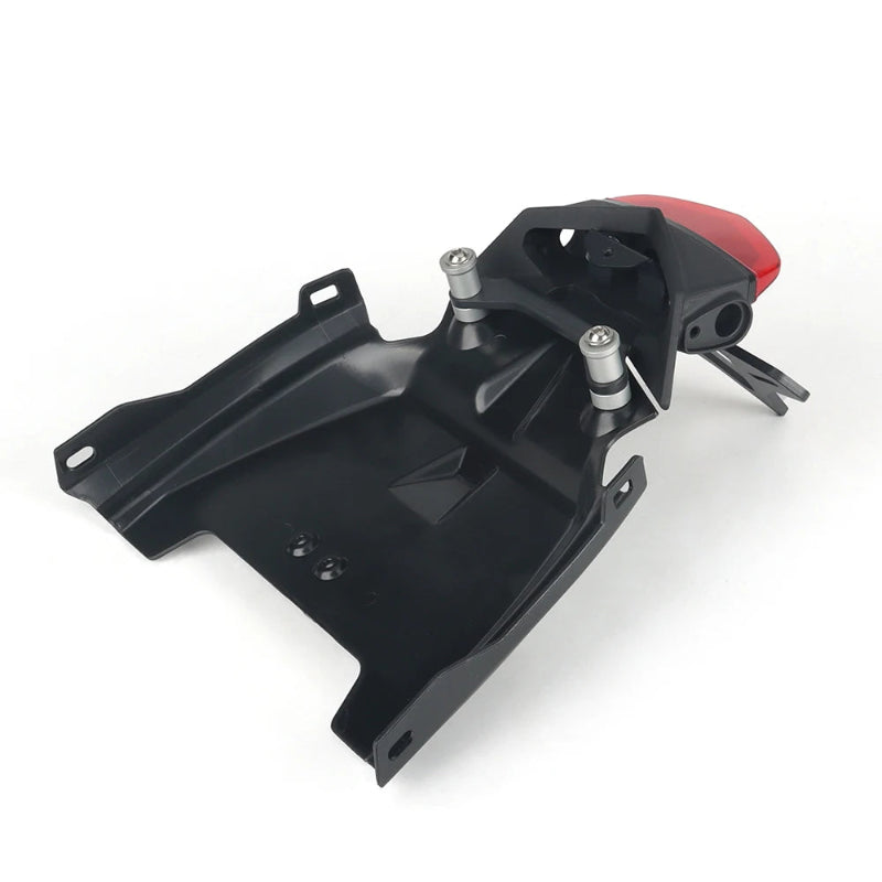 Black plastic motorcycle rear fender and body panel with silver mounting bolts and a small red taillight, shown on a white background.