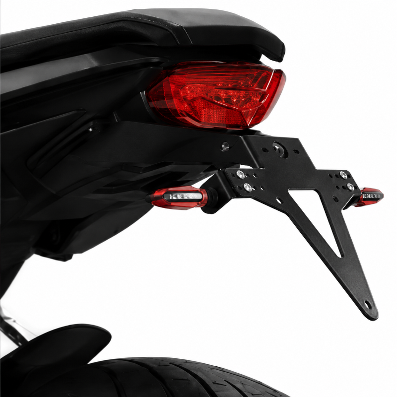 Close-up of a black motorcycle license plate frame and mounting bracket attached behind a red taillight, shown on a white background.