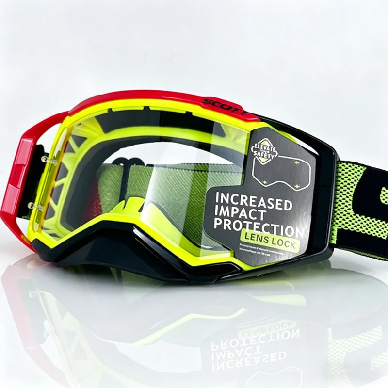 Scott motocross goggles with a red and neon yellow frame, a clear impact-resistant lens, and a black and green strap, shown on a reflective white surface.