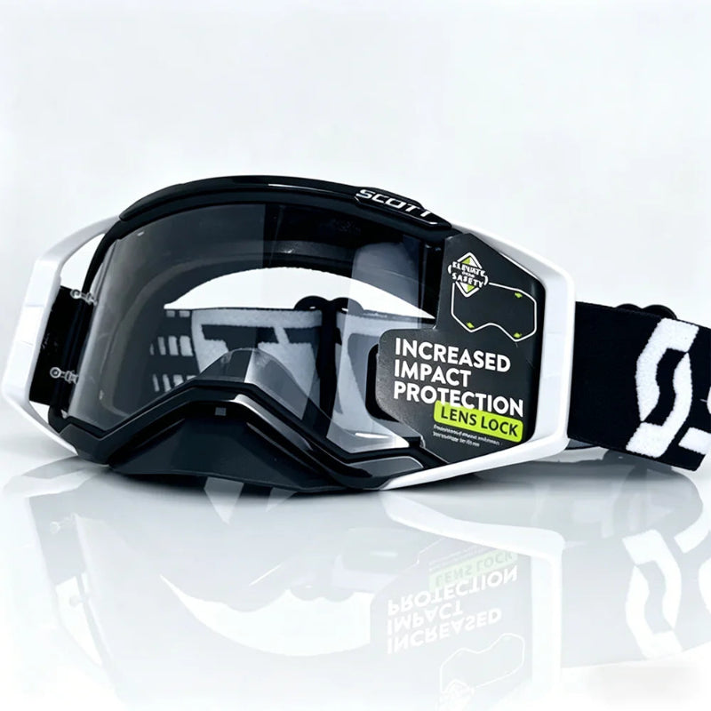 motocross goggles with a black and white frame, dark tinted lens, and a black and white strap, shown on a reflective white background.