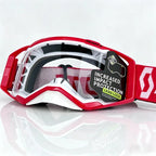 Red and white Scott snowmobile goggles with a clear lens and a black hangtag that reads 'INCREASED IMPACT PROTECTION LENS LOCK'.